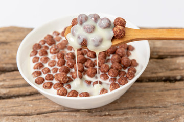 Un bol de leche con bolas de cereal de chocolate
