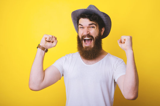 Bearded man looking at the camera making victory gesture.