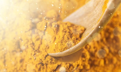 Ground Turmeric powder with wooden spoon