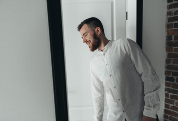 Girl is gathering for a walk. Husband is waiting for wife. Female is preparing for a date. Dressing a newly-married couple. Man standing by the door