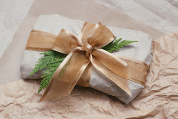 Obraz na płótnie Canvas Gift wrapped in brown paper and tie satin ribbon. Christmas presents. Delivery package. Soft pouch. 