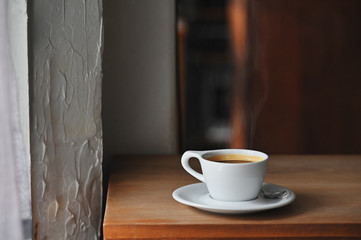 Coffee morning with black coffee on wooden desk.
