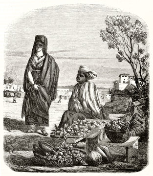 Ancient fruit merchant seated close to his goods outdoor in Rio De Janeiro, Brazil. He looks to a woman getting nearer to buy. By unidentified author publ. on Magasin Pittoresque Paris 1848