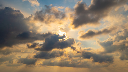 The sun light passes through the clouds at sunset.