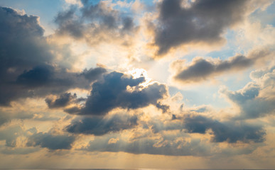 The sun light passes through the clouds at sunset.