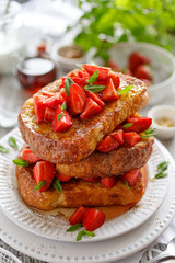 French toasts, French toasts made of sliced brioche with fresh strawberries, honey and mint. Delicious breakfast or dessert