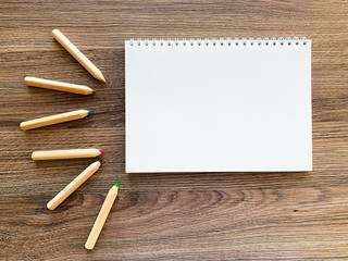 Top view office desk with Empty notebook and pencils on wood table