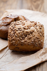 Gold rustic crusty loaves of bread and buns on wooden background. Still life captured from above top view, flat lay.