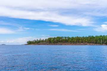Picturesque summer landscape with northern lake coastline in cloudy day. Travelling and discovering distant places of Earth. View from water. Besov nos cape, Onega lake coast, Karelia, Russia