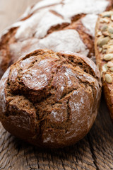 Gold rustic crusty loaves of bread and buns on wooden background. Still life captured from above top view, flat lay.