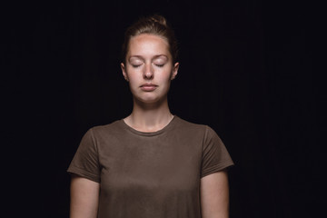 Close up portrait of young woman isolated on black studio background. Photoshot of real emotions of female model with closed eyes. Thoughtful. Facial expression, human nature and emotions concept.