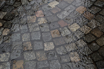 Cobblestone street flooded by rain