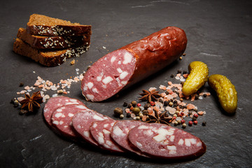 tasty smoked salami sausage with rye bread and pickled cucumbers