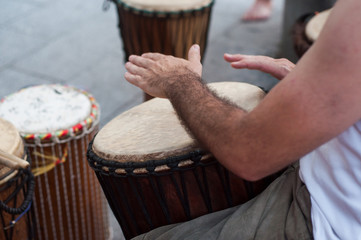 closeup of man hands on african drums in outdoor