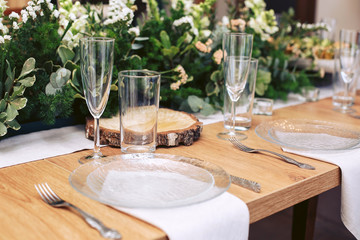 Festive table setting. The decor of natural wood and fresh greens.