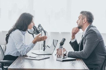 pretty radio host interviewing businessman in broadcasting studio