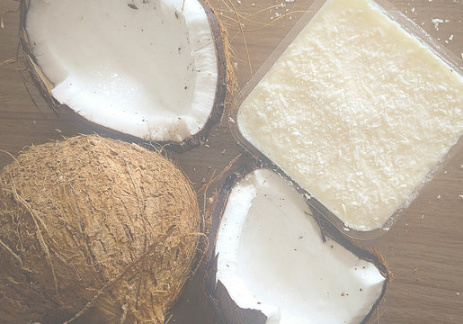 Coco seco aberto junto com doce de coco em fundo amadeirado
