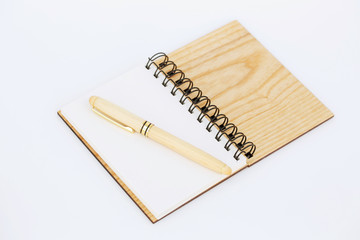 Open notebook with a wooden cover and a pen in a wooden case on it. Isolated on white background.