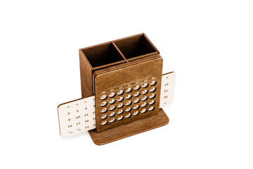 Wooden perpetual calendar made of light and dark wood with pencil stand isolated on white background.