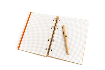 The handle in a wooden case with a cap lies on an empty sheet of an open notebook with a wooden cover. Isolated on white background.