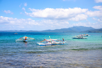 Palawan, the Philippines - 27 Nov 2018: traditional wooden boat in turquoise blue sea. Marine landscape with fishing catamaran