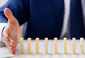 Young businessman playing with domino in office