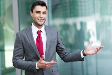Young businessman outdoor welcoming you