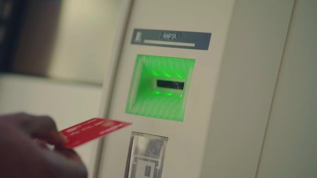 Close up view of male hand entering pin code, using credit card to withdraw money from ATM. Money, bank, finance and people concept. Banking services