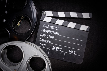 Multiple film reels and a clapboard on a wooden background. Film, Hollywood, entertainment industry...