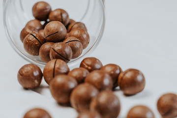 inshell macadamia nuts on light gray background. macadamia in a glass jar	