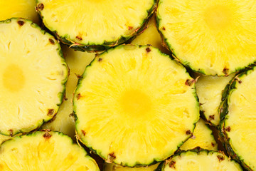 Pineapple juicy yellow slices background. Top view.