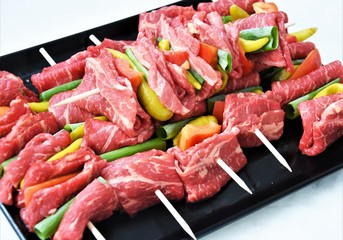 fresh beef meat with pepperoni and paprika on a wooden stick