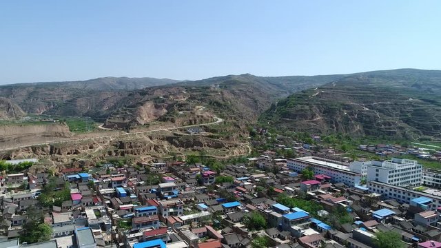 Aerial view of small village & farm field next mountain & valley during hot dry summer season with blue sky, Tianshui, Gansu Province, China, 