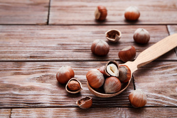Hazelnuts with spoon on wooden table