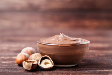 Melted chocolate with hazelnuts on brown wooden table