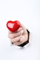 Fototapeta premium Hand holding red heart from white torn paper