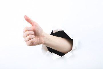 Hand from white torn paper
