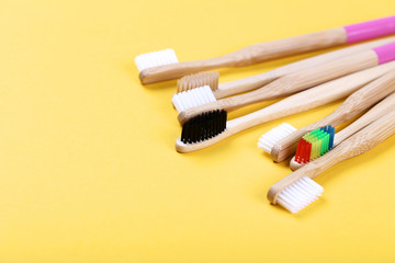 Bamboo toothbrushes on yellow background