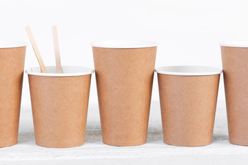 Eco-Friendly disposable paper cups and wooden sticks on the table