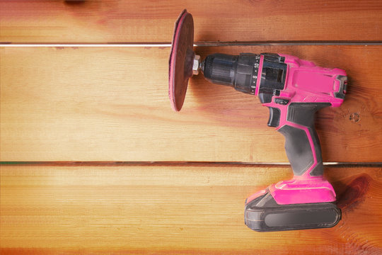 One power tool with a sander is laying on a wooden surface