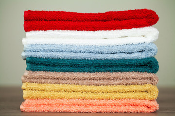 Stack colorful towels in bathroom on table