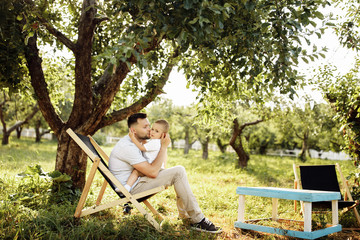 Happy young father with little son play in the park at summer