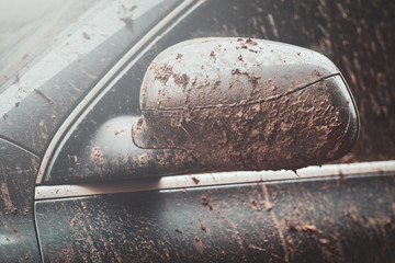 Closeup photo shoot of dirty car's mirror, splash and texture of mud on silver car.