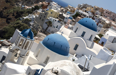 Traditional Greek white church arch with cross and bells in village Oia of Cyclades Island...