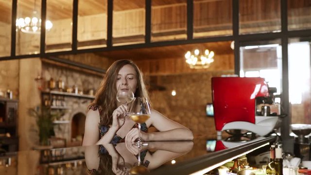 woman smelling and looking on white wine in glass and drinking for degustation. 4k handheld
