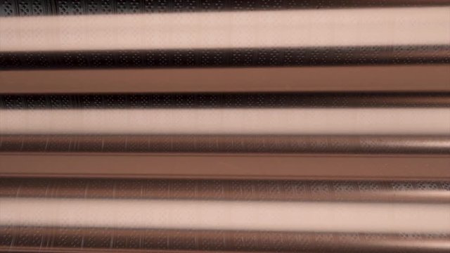 Horizontal brown lines on metallic background, seamless loop. Animation. Abstract parallel wide stripes of beige and brown colors flowing slowly.