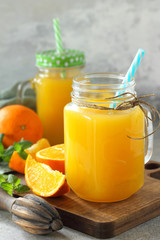 Refreshing juice made of orange, cold drink on a stone or slate background. Concept fresh vitamins. Rustic style. Free space for your text.
