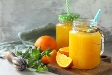 Naklejka na ściany i meble Refreshing juice made of orange, cold drink on a stone or slate background. Concept fresh vitamins. Rustic style. Free space for your text.