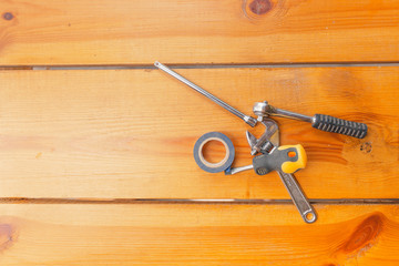 A various assortment of tools is laying on a wooden surface