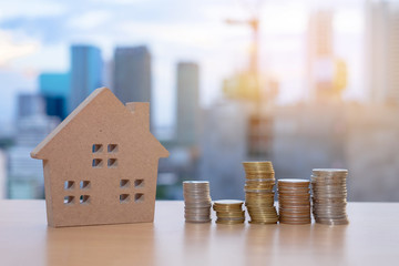 Wooden house models and coins arranged in rows On the backdrop of the building. House buyer real...